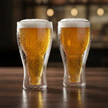 Upside down beer glasses filled with golden lager on dark wood bar surface